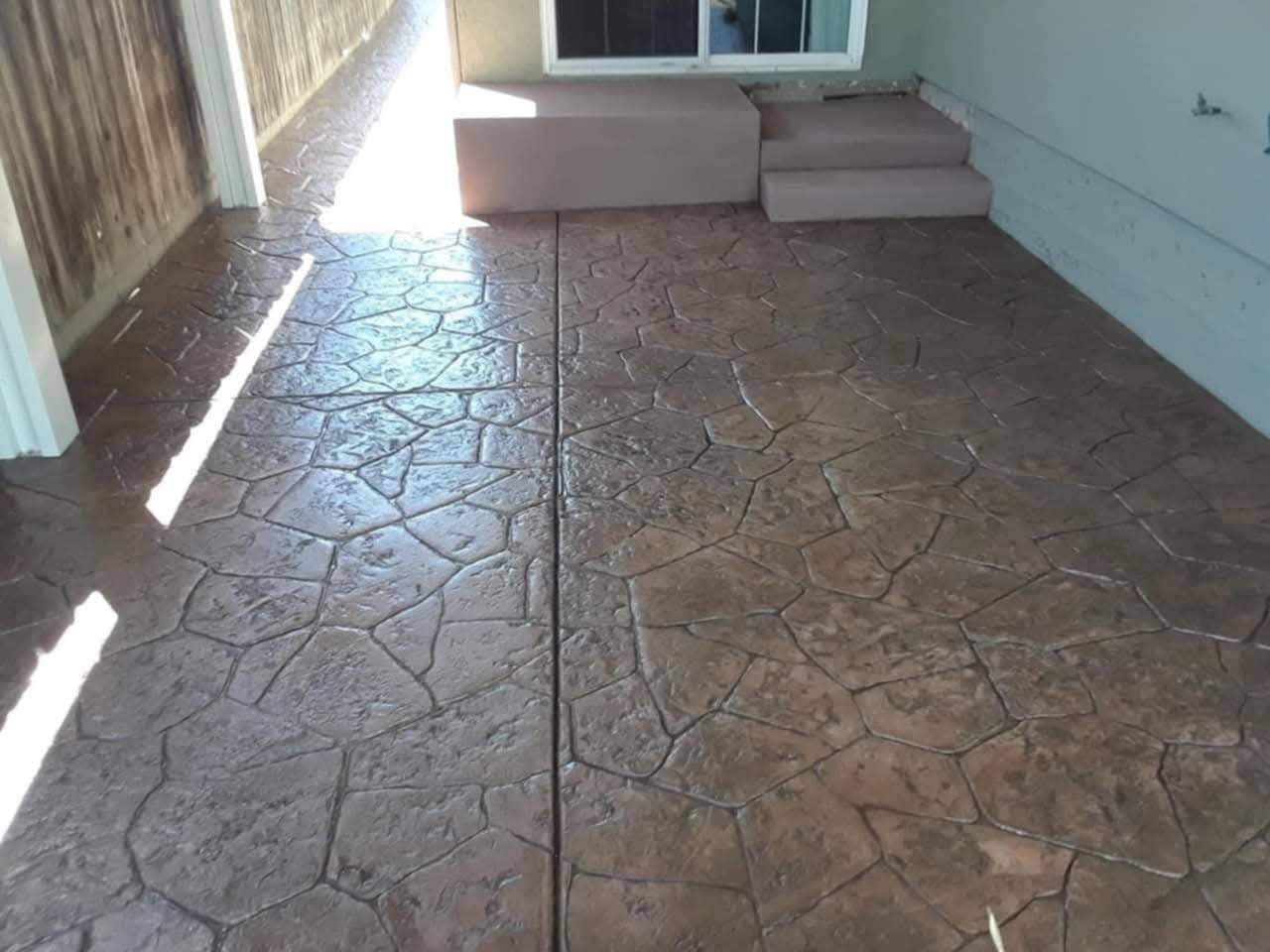 Glossy sealed stamped-flagstone patio under a covered porch