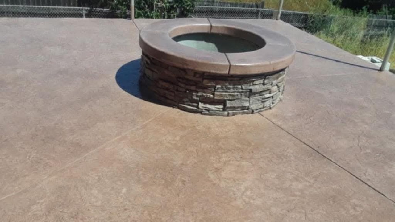 Stamped concrete patio with a round stacked-stone fire pit